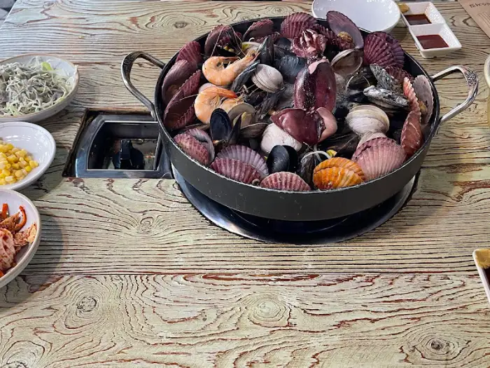 해물백숙이 담긴 냄비와 주변 반찬들