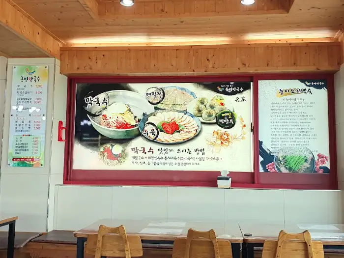 메뉴판에 메밀막국수와 능이백숙 사진이 나와있는 모습
