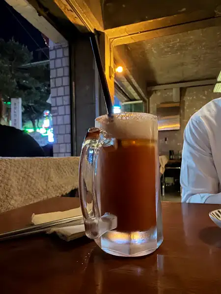 가장자리에 거품이 풍성하게 올라온 아이스 맥주잔