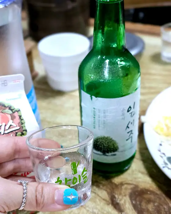 소주잔에 따라진 소주와 함께 놓인 찌개
