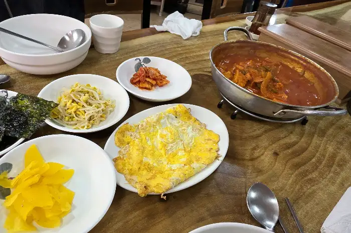 테이블에 놓인 찌개와 밥, 계란 프라이 등