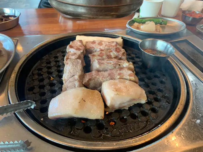 금돈가 흑돼지 목살과 오겹살이 불판 위에서 익어가는 모습