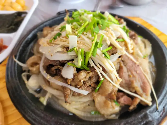돼지갈비 위에 신선한 버섯과 파채가 듬뿍 올라가 있어 풍성한 느낌을 주는 모습