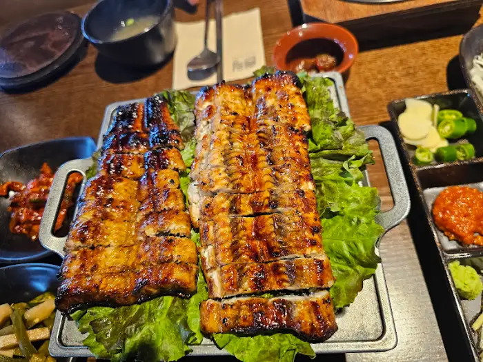 먹음직스럽게 구워진 민물장어 숯불구이, 깻잎 위에 올려져 나온 모습