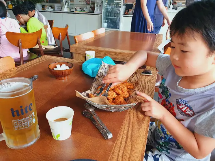 치킨을 맛보는 아이의 즐거운 표정과 맥주잔