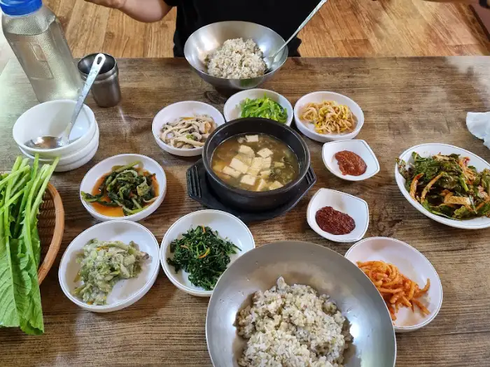 풍년초 보리밥 식당의 보리밥과 된장찌개, 그리고 여러 나물 반찬이 차려진 모습