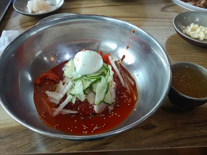 비빔냉면에 고명을 얹고 계란 지단을 곁들인 모습