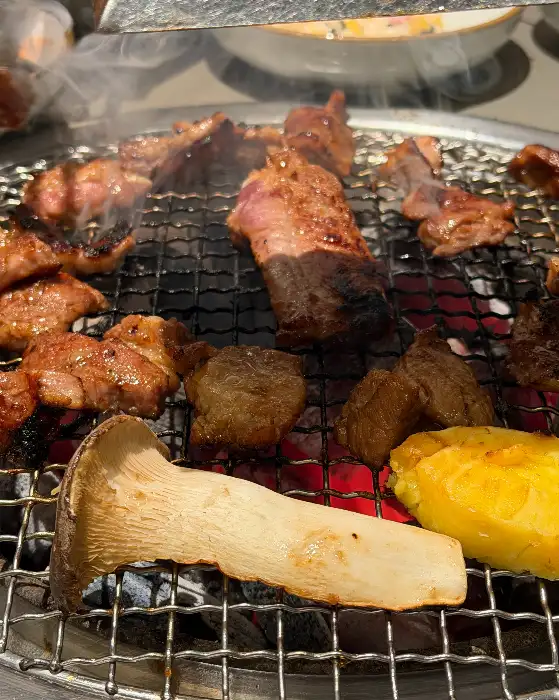 숯불 위에서 맛있게 익어가는 돼지갈비와 버섯