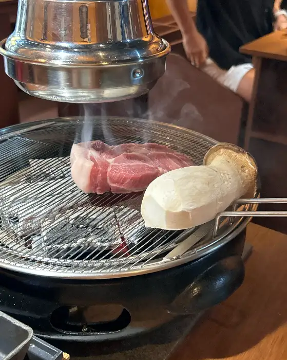 새로운 목살 한 점이 숯불 위에서 익어가고 있다.