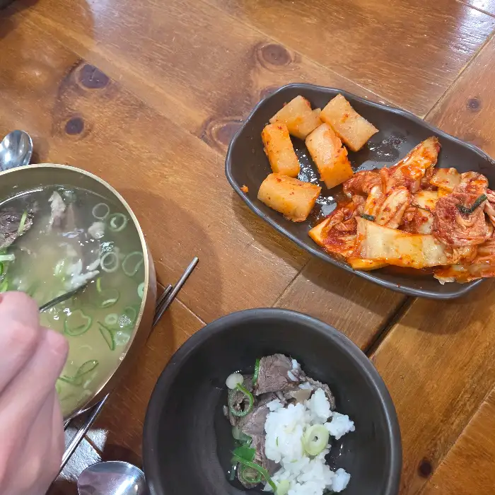 식탁 위 곰탕과 반찬들