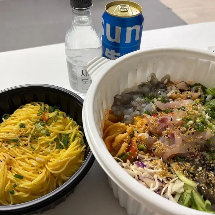 비빔밥 위에 올려진 신선한 회와 채소