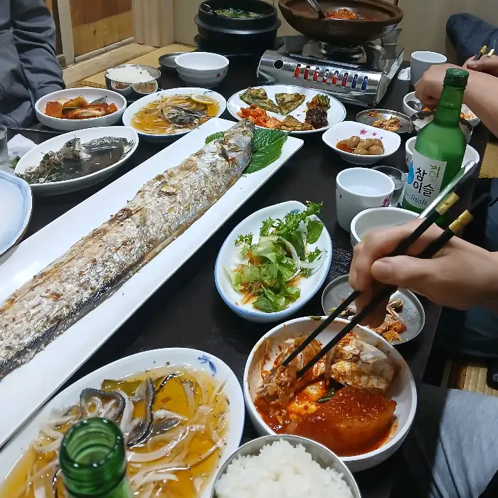 길쭉한 은색 접시에 담긴 통갈치 구이