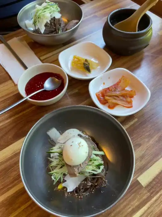 막국수, 김치, 겉절이, 백김치, 쌈무가 담긴 상차림