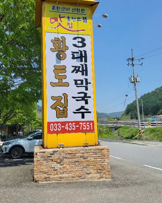 황토집 간판이 보이는 건물 외부 및 주차장