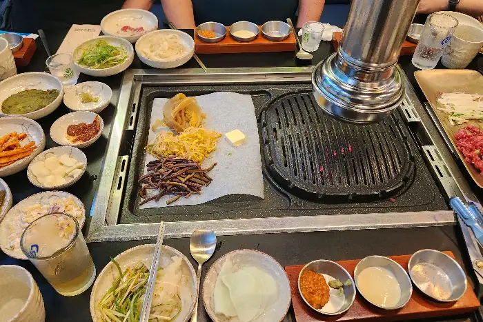 다양한 곁들임 채소와 소스가 정갈하게 차려진 테이블 모습