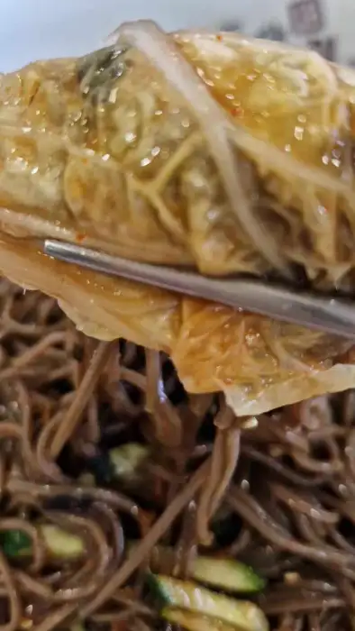 젓가락으로 집어 올린 묵은지 김치전