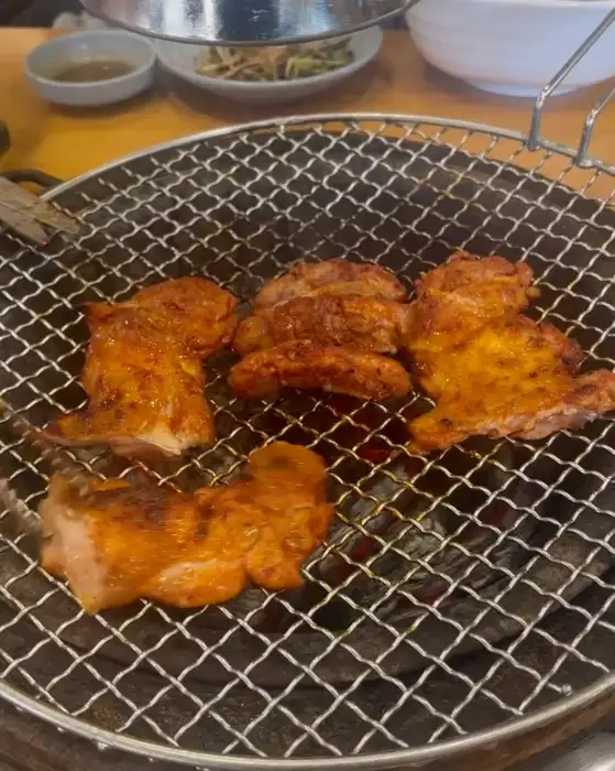 그릴 위에서 구워지고 있는 닭갈비 조각들