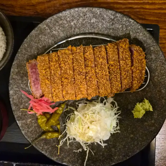 플레이팅된 규카츠, 곁들임 반찬, 와사비 등이 보인다.
