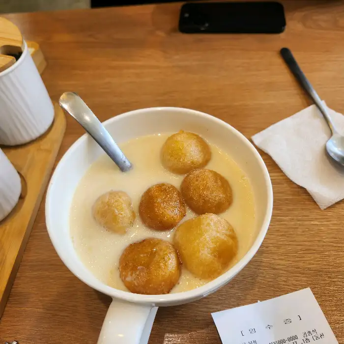 콩국 안에 찹쌀 도넛이 여러 개 들어있는 모습.