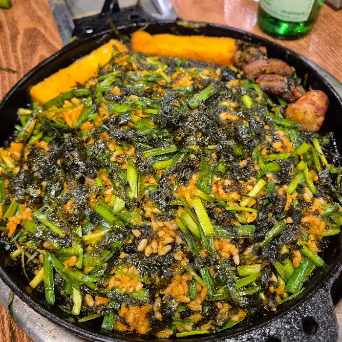김가루와 부추가 듬뿍 올라간 볶음밥이 팬 위에서 맛있게 익어가고 있는 모습.