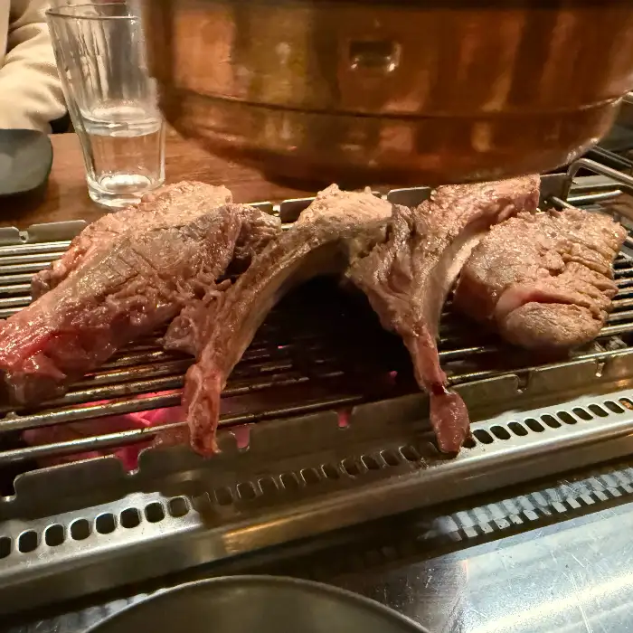 다양한 부위의 양고기들이 숯불 위에서 익고 있는 모습