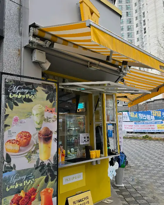 노란색 어닝이 쳐진 메가커피 매장 외관
