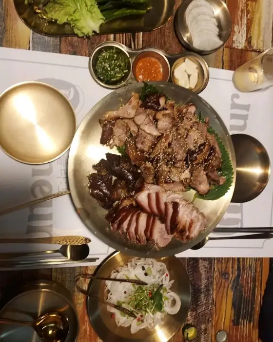플레이팅 된 족발, 막국수, 쌈 채소 등 다양한 음식