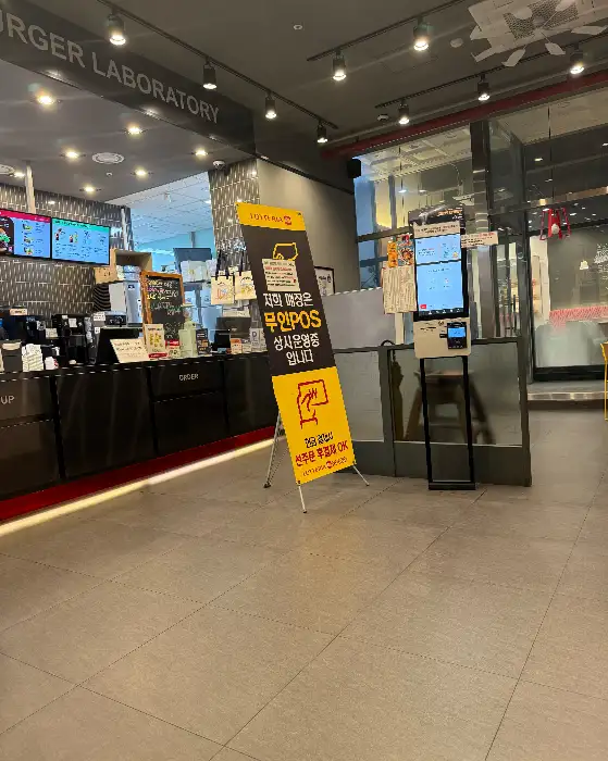 무인POS 운영 안내 배너가 세워진 롯데리아 매장 내부