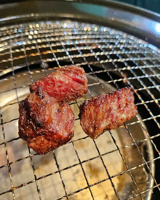 잘 익은 소고기 조각들, 숯불 위에서 익어가고 있습니다.