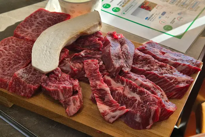 잘 손질된 한우 모듬과 버섯, 신선한 채소가 먹음직스럽게 담긴 접시