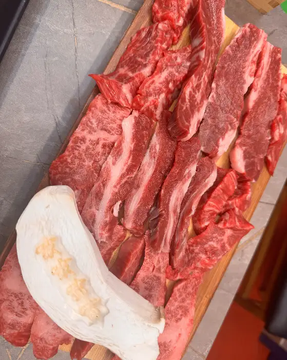 잘 손질된 한우 고기들이 나무 도마 위에 가지런히 놓여 있는 모습