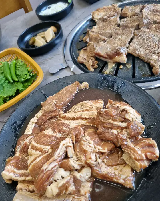 양념된 돼지갈비와 쌈 채소, 깻잎, 고추 등이 함께 나온 모습