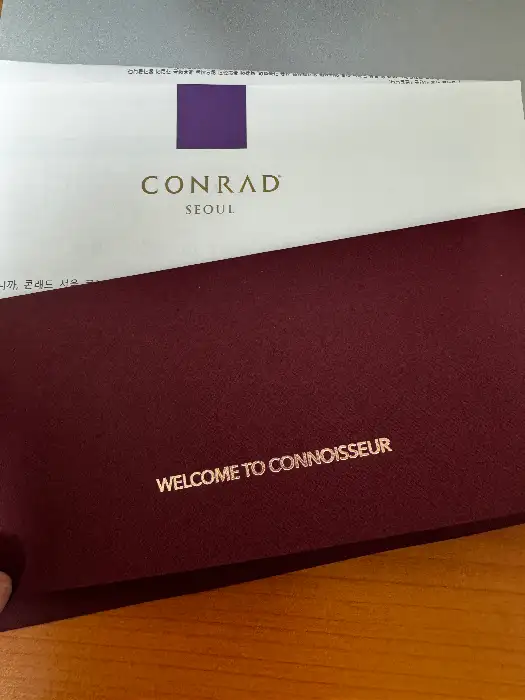 conrad seoul 로고가 보이는 고급스러운 서류철