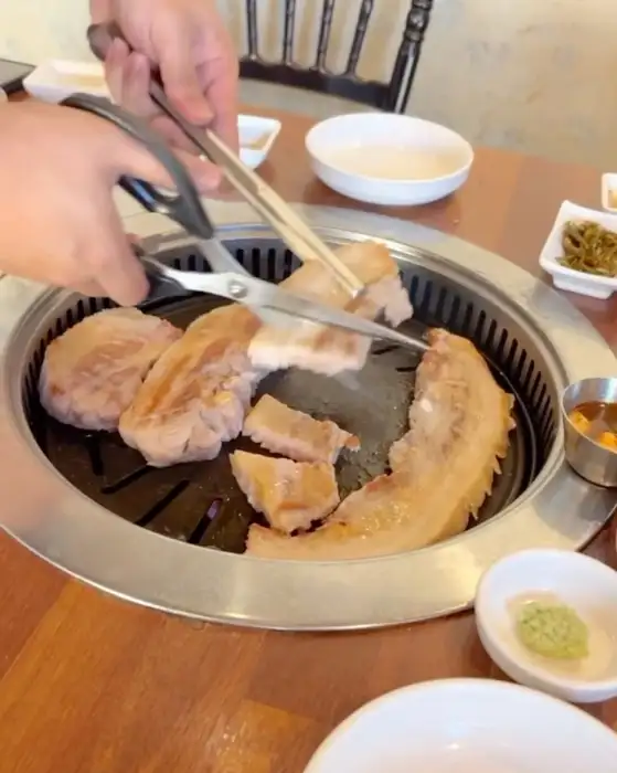 다양한 부위의 고기가 숙성고 안에서 보라색 조명 아래 숙성되는 모습
