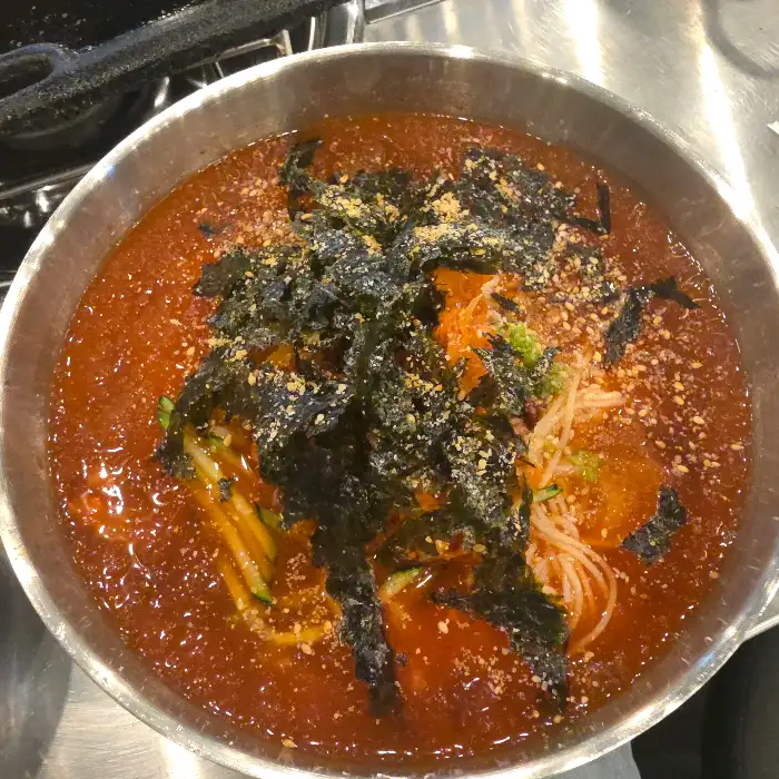 김치냉국수에 면과 김, 오이가 담겨 있는 모습