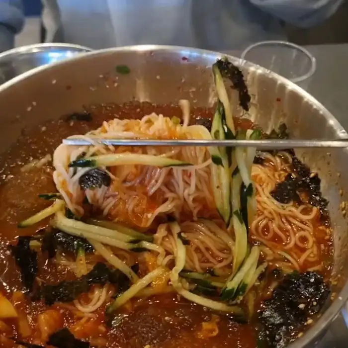 젓가락으로 집어 올린 비빔국수의 면발