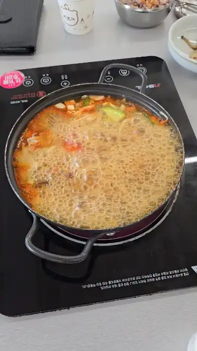 김치찌개 안에 두부, 버섯, 채소 등이 보이는 모습