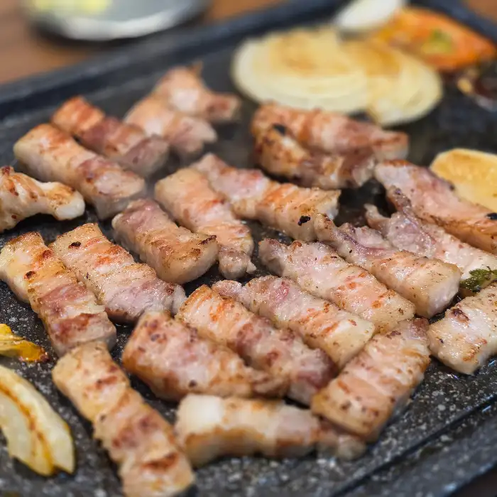 불판 위에서 맛있게 익어가고 있는 삼겹살의 모습