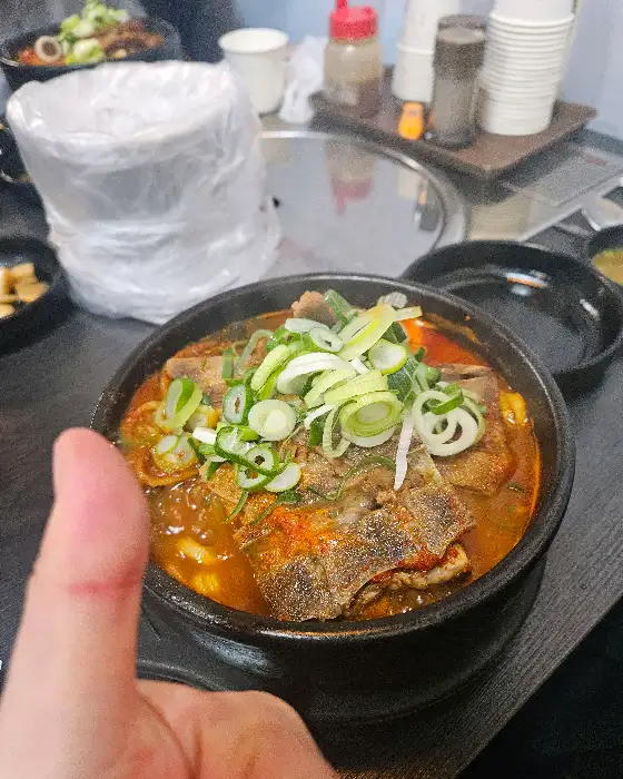 엄지 척을 하며 뼈해장국을 보여주는 모습