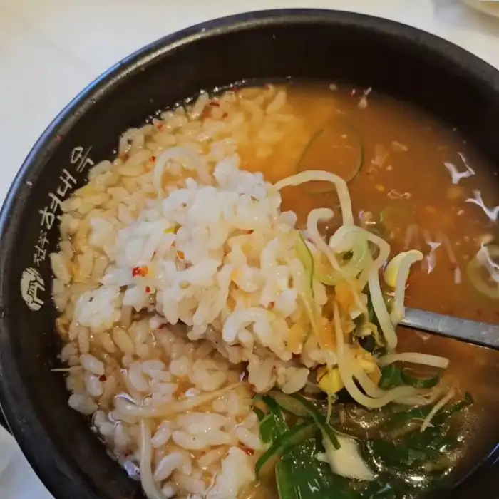 숟가락으로 뜨 올린 콩나물국밥의 밥과 콩나물 모습