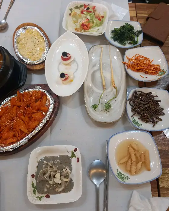 산더덕으로 보이는 요리와 다양한 밑반찬