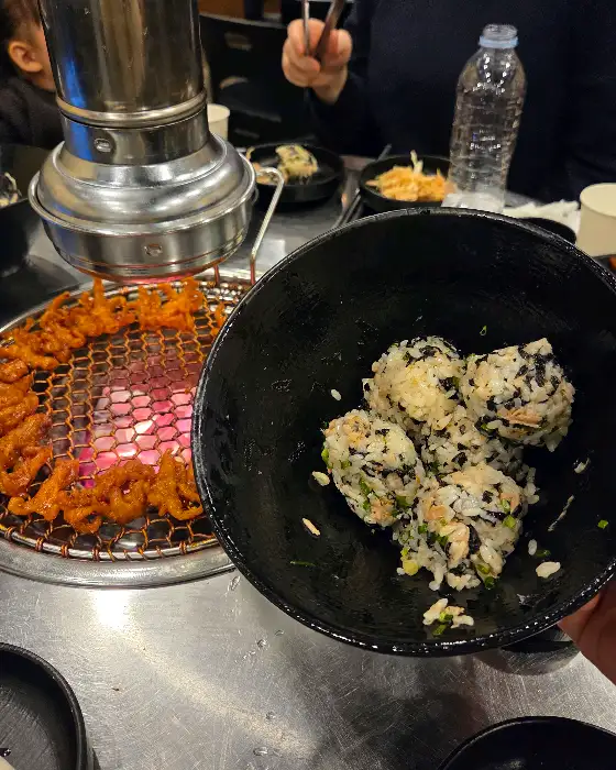 숯불 위에서 구워지고 있는 돼지고기와 주먹밥