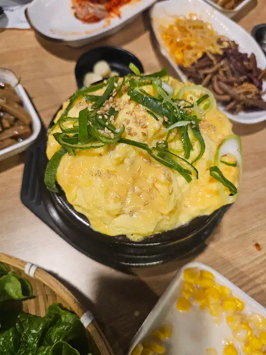 볶음밥 위에 올려진 계란찜과 곁들임 반찬들
