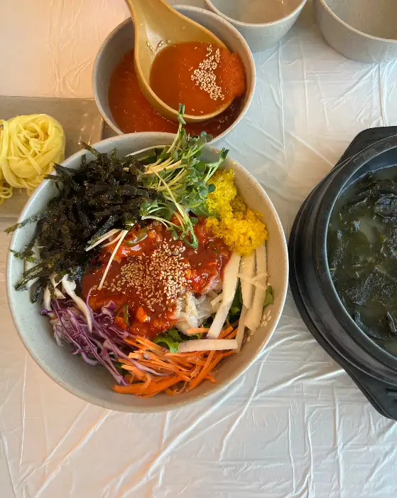비빔 물회, 소면, 쯔양세트에 포함된 전복죽이 함께 놓인 모습