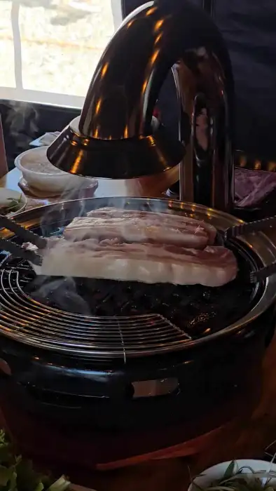 숯불 위에서 노릇하게 구워지고 있는 삼겹살