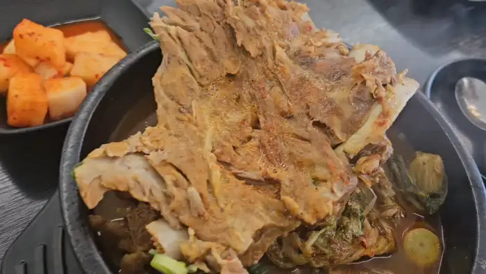 뼈국 뚝배기 위에 뼈가 푸짐하게 올라가 있는 모습