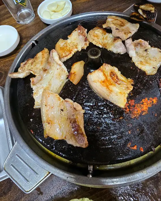 솥뚜껑 불판 위에서 노릇하게 구워지는 삼겹살
