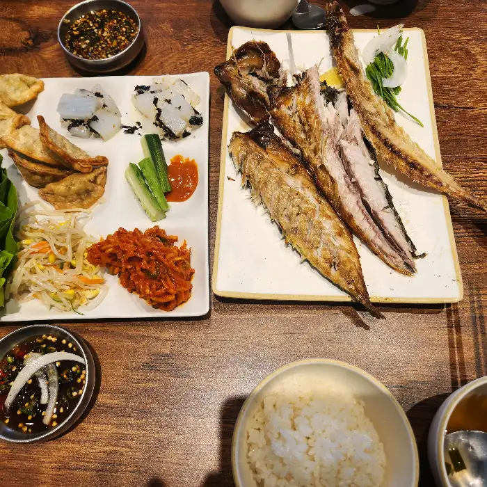셀프바에 준비된 다양한 반찬들, 샐러드, 김치, 떡볶이, 튀김 등이 보입니다.