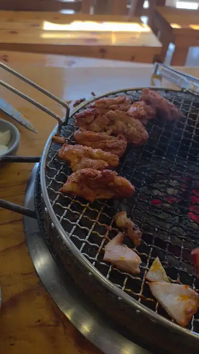 숯불 위에서 익어가는 닭갈비 조각들