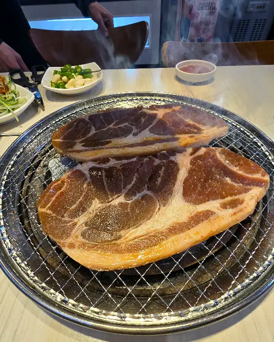 숯불 위에서 익고 있는 두툼한 통삼겹살